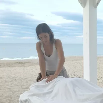 Anabel, socia de masaje a cuatro manos haciendo un masaje californiano en la playa.