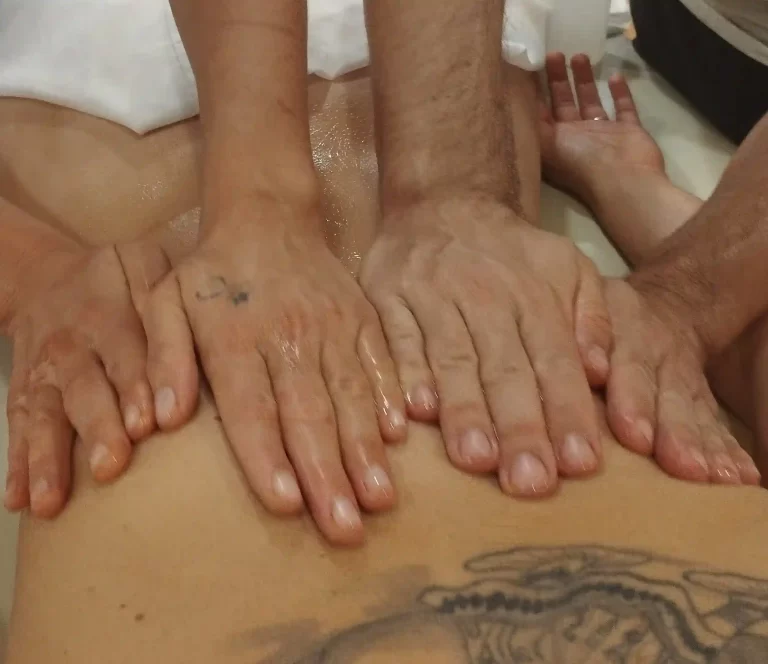 Pase largo en un masaje a cuatro manos. Cada masajista en un lado de la camilla pasa desde la cadera o lumbares hasta la nuca.